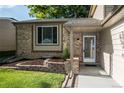 Inviting front entrance featuring a brick facade, covered porch, and well-maintained landscaping at 17657 E Prentice Cir, Aurora, CO 80015