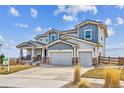 Two-story home with a stone and siding exterior, three-car garage, well-manicured front lawn, and for sale sign at 16272 W 95Th Ln, Arvada, CO 80007