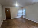 Bright living room featuring hardwood floors, a large window, and a classic front door at 4209 Perry St, Denver, CO 80212