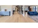 Expansive living area with light hardwood floors and staircase, perfect for entertaining and relaxation at 2635 S Monroe St, Denver, CO 80210