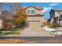 Two-story house with attached garage and autumn landscaping at 14449 E 101St Pl, Commerce City, CO 80022