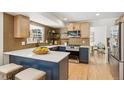 Modern kitchen featuring stylish blue cabinets, a quartz countertop island, stainless steel appliances, and hardwood floors at 6330 E Irwin Pl, Centennial, CO 80112