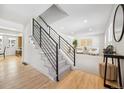 Bright entryway with a staircase, leading to a living room with neutral decor, white sofas, and stylish artwork at 6330 E Irwin Pl, Centennial, CO 80112