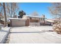 Brick ranch home with attached garage and driveway, snow on the ground at 1859 S Saulsbury Ct, Lakewood, CO 80232