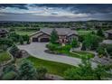 Beautiful exterior with lush landscaping, stone facade, circular driveway leading to an attached two-car garage, and horizon views at 4822 Bandera Pl, Parker, CO 80134
