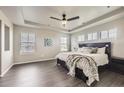 Spacious main bedroom with tray ceiling, wood floors, and large windows at 785 Iris St, Brighton, CO 80601