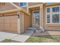 Close up of a inviting front entrance with beautiful details and a three car garage to the side at 1045 English Sparrow Trl, Highlands Ranch, CO 80129