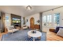 Bright living room with fireplace, modern furniture, and arched doorway to other rooms at 1582 Fairfax St, Denver, CO 80220