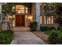 Stately home showcasing a grand double-door entrance with detailed stonework and landscaping at 96 Falcon Hills Dr, Highlands Ranch, CO 80126