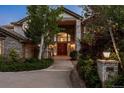 Elegant stone home featuring a grand entrance with double doors and manicured landscaping at 96 Falcon Hills Dr, Highlands Ranch, CO 80126