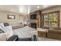 Cozy living room with stone fireplace, plush seating, and scenic views from large windows and balcony at 107 Skiwatch Dr # 329, Breckenridge, CO 80424