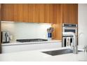 Close-up of the kitchen featuring a gas range, sleek backsplash, and stainless steel appliances at 4200 W 17Th Ave # 611, Denver, CO 80204