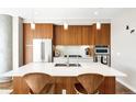 Modern kitchen boasts wooden cabinetry, stainless steel appliances, and a spacious island with seating at 4200 W 17Th Ave # 611, Denver, CO 80204
