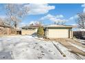 Ranch style home with attached garage and snowy front yard at 6922 Vance St, Arvada, CO 80003