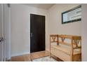 Neutral entryway featuring hardwood floors, coat rack, mirror, and wooden storage bench at 410 Acoma St # 515, Denver, CO 80204