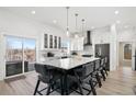 Modern eat-in kitchen boasts white cabinets, stainless appliances, large island and access to a balcony at 6725 Beech Ct, Arvada, CO 80004