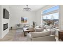 Spacious living room with large windows, wood floors, fireplace, and comfortable seating at 6725 Beech Ct, Arvada, CO 80004