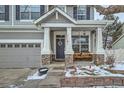 Inviting covered front porch with stately columns, bench seating, and decorative accents at 11191 Cimarron St, Firestone, CO 80504