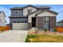 Charming two-story home with a brick entryway, gray siding and an attached garage at 11744 Magnolia Dr, Thornton, CO 80233