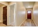 Warm entryway with a red front door, wood-look flooring, and neutral paint, creating a welcoming atmosphere at 11129 Paradise Ln, Firestone, CO 80504