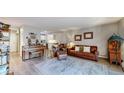 Bright living room with wood floors, neutral paint, and seamless flow to kitchen area at 13626 E Bates Ave # 302, Aurora, CO 80014