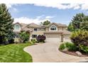 Inviting home exterior featuring a curved driveway, well-manicured lawn, and a two-car garage at 5301 S Birch Ct, Greenwood Village, CO 80121