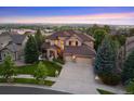 Beautiful exterior of home with meticulous landscaping and a long driveway on a large lot at 12147 S Shady Pine Ct, Parker, CO 80134