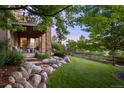 The home's outdoor space includes a stone patio, a wooden fence, and lush green grass at 12147 S Shady Pine Ct, Parker, CO 80134