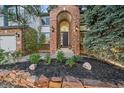 Charming front entrance showcasing brick archway, decorative lighting, and manicured landscaping at 10125 Quarry Hill Pl, Parker, CO 80134