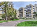 Multi-story condominium building with mature landscaping and trees at 13691 E Marina Dr # 107, Aurora, CO 80014