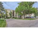Multi-story condominium building surrounded by mature trees and shrubs at 13691 E Marina Dr # 107, Aurora, CO 80014