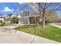 Charming two-story home with a lush green lawn, two car garage, and lovely curb appeal at 19447 E Bellisario Creek Dr, Parker, CO 80134