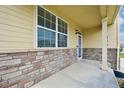 Charming front porch showcases brick accents, a covered entrance, and a cozy welcome at 443 Hermosa St, Brighton, CO 80603