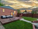 Inviting backyard with a wooden deck, comfortable seating, and a lush green lawn surrounded by a fence at 3401 N Steele St, Denver, CO 80205