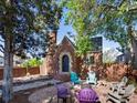 Charming brick home featuring a landscaped front yard with fire pit and colorful Adirondack chairs at 3401 N Steele St, Denver, CO 80205