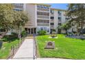 Inviting condo building exterior with manicured lawn and accessible ramp entrance at 3164 S Wheeling Way # 302, Aurora, CO 80014