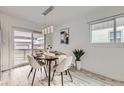 Dining area with modern lighting, wood table, neutral chairs, and sliding door access at 3440 Chase St, Wheat Ridge, CO 80212