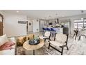 Open-concept living space featuring modern furnishings, a kitchen island, and a dining area at 3440 Chase St, Wheat Ridge, CO 80212