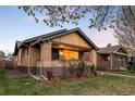 Charming brick home with a well-manicured lawn and inviting front porch with mature trees overhead at 1918 S Lincoln St, Denver, CO 80210