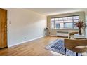 Sunny living room with hardwood floors, large window, neutral paint, and comfortable chair at 1523 Ivy St # 6, Denver, CO 80220