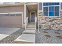 Close up of a home's entrance featuring stone accents, stairs, and an attached garage at 483 Basin Daisy St, Castle Rock, CO 80104