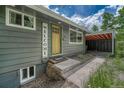 Close-up of the front entrance featuring a yellow door and 'Welcome' sign at 25694 Stansbery St, Conifer, CO 80433