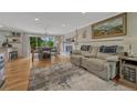 Open-concept living room with hardwood floors, a fireplace, and deck access at 25694 Stansbery St, Conifer, CO 80433