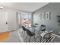 Bright dining room with a glass table, designer chairs, bay window, and stylish wall decor at 5285 S Jericho Way, Centennial, CO 80015