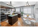 Modern kitchen with dark cabinetry, stainless steel appliances, and a central island with a glass countertop at 5285 S Jericho Way, Centennial, CO 80015