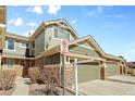 Charming townhome featuring a two-car garage and attractive stone accents at 15063 E Crestridge Dr, Centennial, CO 80015