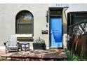 A inviting exterior showcasing a blue front door and sitting area with a chair and side table at 361 Elati St, Denver, CO 80223