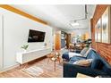 Bright living room featuring exposed brick, hardwood floors, and stylish modern furnishings at 361 Elati St, Denver, CO 80223