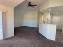 An open-concept living room boasts vaulted ceilings, carpet flooring and a pass-through to the kitchen for easy entertaining at 7777 S Biloxi Way, Aurora, CO 80016