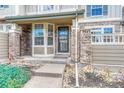 Close-up of townhome entrance showcasing stone pillars, covered entryway, and secure front door at 8943 Tappy Toorie Cir, Highlands Ranch, CO 80129